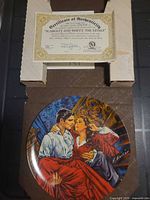 Plate face showing artwork, COA on top of box insert