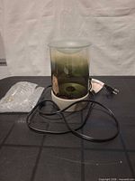 Front view showing green glass shade, stone base, cord, plug and bulb