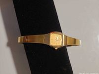 Front view of Seiko gold-tone square bracelet watch on display stand