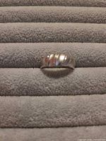 Front view of sterling domed ribbed ring on padded surface