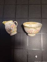 Creamer pitcher and sugar bowl side by side on tabletop