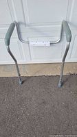 Front view of toilet safety frame showing padded armrests and legs