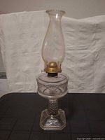 Full view of oil lamp showing base, font, burner, chimney
