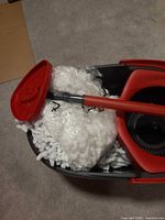 Overall view of Vileda Easy Ring bucket with red wringer, mop handle and packaged mop heads
