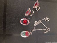 Set showing necklace and both earrings on black surface