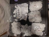 Six bags filled with white felt circles