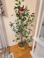 Full view of artificial tree in gold planter