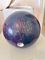 Front view showing Atomic Charge logo and finger holes