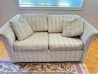 Front view of beige/cream 2-seat sofa with pillows