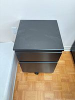 Front and side view of black 2-drawer cabinet on casters