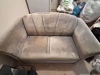Front view showing entire gray loveseat with velvet/microfiber upholstery