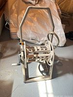 Front view of beige Hosemobile hose reel cart with hose on drum and handle upright