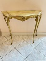 Front view of console table showing gilded frame and marble top
