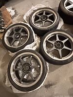 Four matching gunmetal wheels with tires grouped