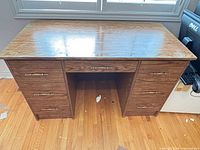 Front view of desk showing all seven drawers and laminate finish