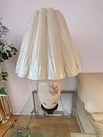 Full lamp with shade on glass side table