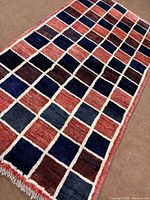 Full view of Gabbeh rug showing checkerboard design and fringe