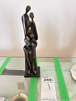 Front view of bronze abstract family sculpture on glass surface