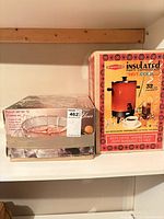 Both boxed items on shelf: punch set left, coffeemaker right