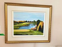 Framed oil landscape painting hung on wall