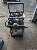 Front view of Graphite hose reel cart with hose, fittings and nozzle on tray