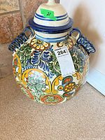 Full view of lidded ceramic jar showing pattern, lid, lot sticker