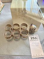 overview of six napkin rings and condiment pot with label