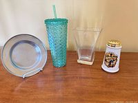 Front view of all four items: metal plate, rhinestone tumbler, glass vase, ceramic cheese shaker