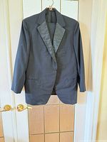 Front view of jacket on hanger, displays lapel and button configuration