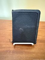 Front cover of black pebbled leather pocket Bible standing upright