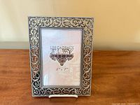 Front view of ornate silver filigree frame with placeholder insert