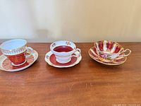 Three teacup and saucer sets displayed side by side