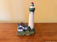 Front view of lighthouse figurine showing tower and cottage