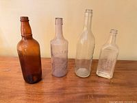 Group of four glass bottles standing on table