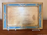 front of rectangular gilt and turquoise tray