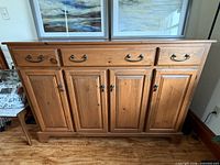 Front view of pine buffet showing three drawers, four doors, brass hardware