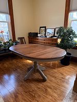 Full view of table showing walnut top, gray pedestal base, leaf installed