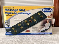 Front of retail box showing image of massage mat, brand and features