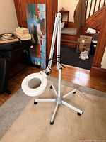 Full view of adjustable magnifier lamp on rolling base