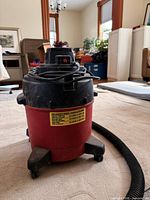 Front view of 4-gallon Shop-Vac showing tank, lid, cord and hose