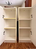 Interior view of two white Billy bookcases showing adjustable shelves and slight yellowing on left unit trim