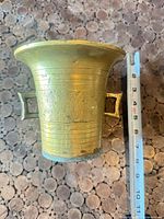 Side view of brass mortar with tape measure showing ~5.5 in. height