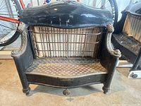Front view of antique cast iron fireplace insert showing decorative design and grate