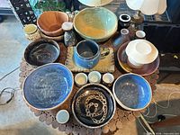 Overhead view of all fifteen ceramic pieces arranged on round surface