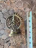 Front view of brass Dancing Shiva figurine with ruler showing height