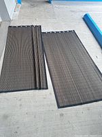 Two woven bamboo curtain panels laid flat showing full size, grommets, and edging