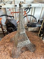Full view of the openwork metal Eiffel Tower sculpture on cork surface