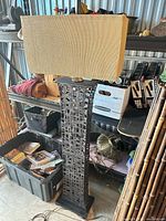 Full view of the black metal lattice floor lamp with rectangular beige shade