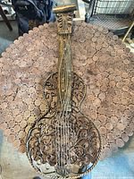 Front view of ornate metal guitar sculpture on table surface