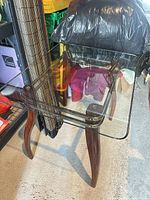 Full view of glass top accent table showing glass surface and wood legs